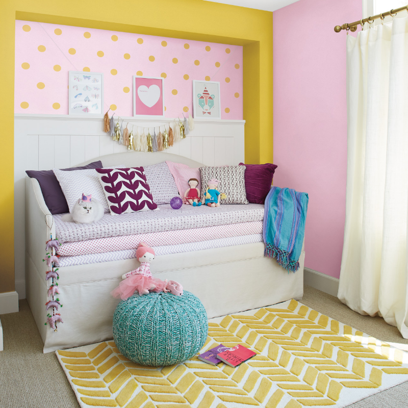 A whimsical nursery with a comfy trundle, a white cat and a playful yellow polka dot pattern on a painted reagan’s tu-tu.