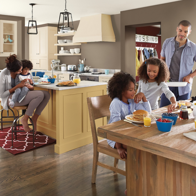 A family enjoying breakfast in a large kitchen with a dining table and island.