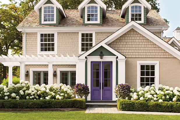 Front of a large house with beige siding, white trim, purple front French doors.