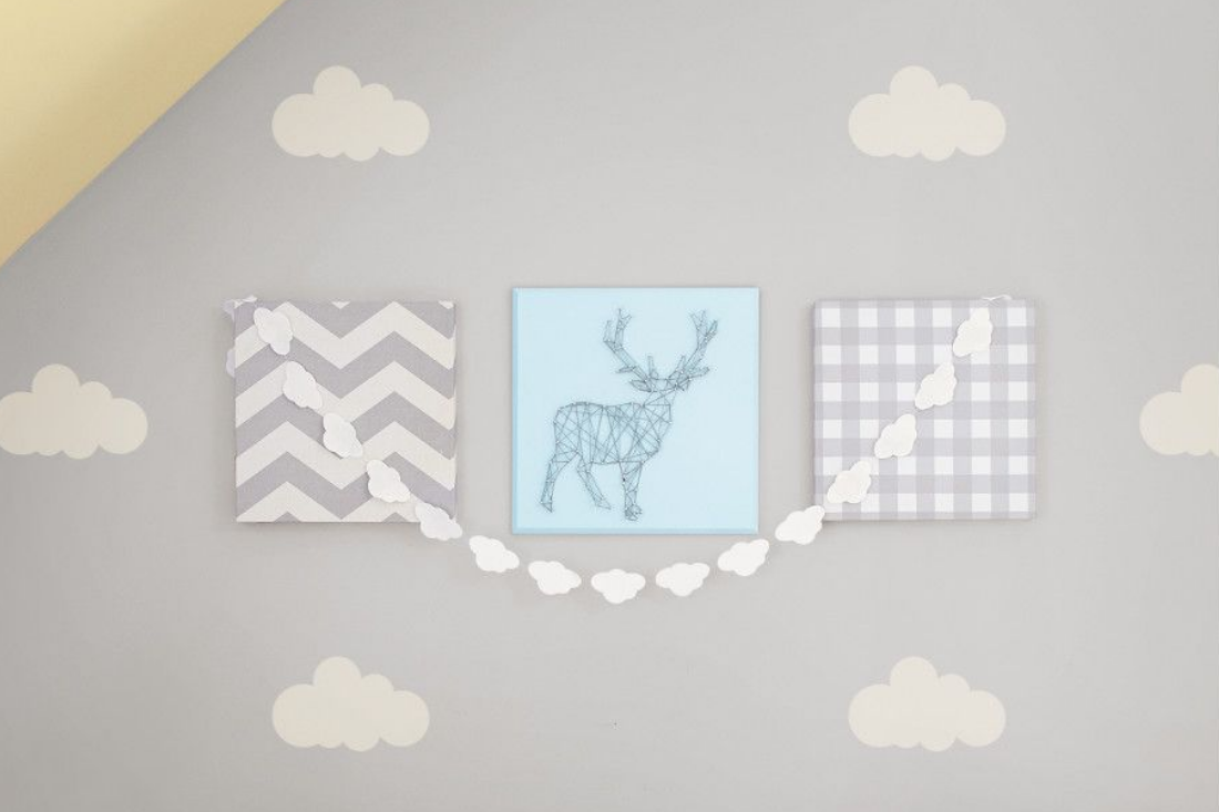 A nursery features stenciled white clouds on a grey wall for a whimsical feel.